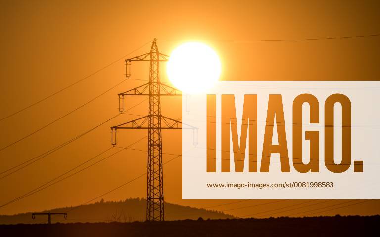 Sunset behind power pole 22 02 2018 Kronberg The sun goes behind the mast of a high voltage power line under Kronberg Germany