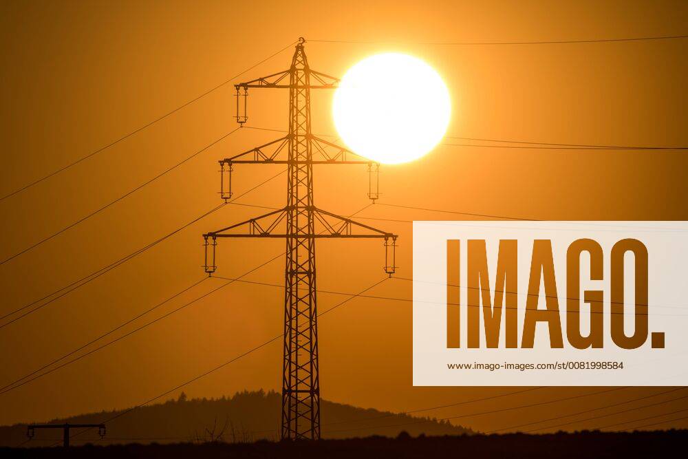 Sunset behind power pole 22 02 2018 Kronberg The sun goes behind the mast of a high voltage power line under Kronberg Germany