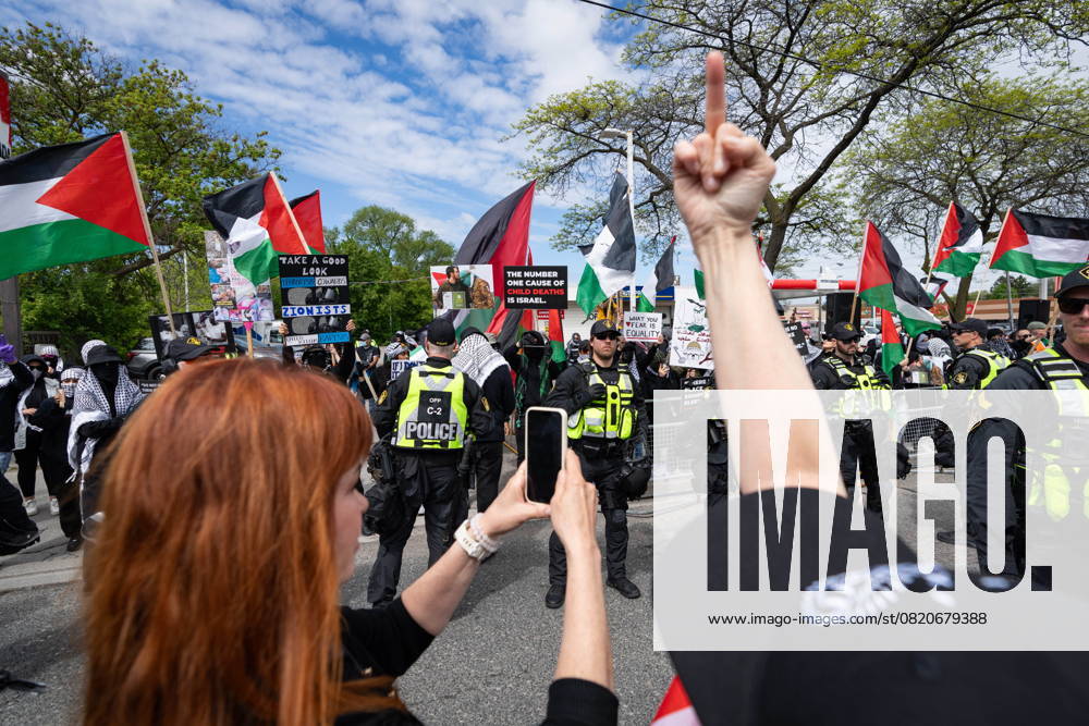 People gesture at pro-Palestinian protesters gathered along the route of the United Jewish Appeal s annual Walk With Israel march in Toronto on Sunday, May 25, 2025. Toronto Canada - ZUMAc35_ 20250525_zaf_c35_010