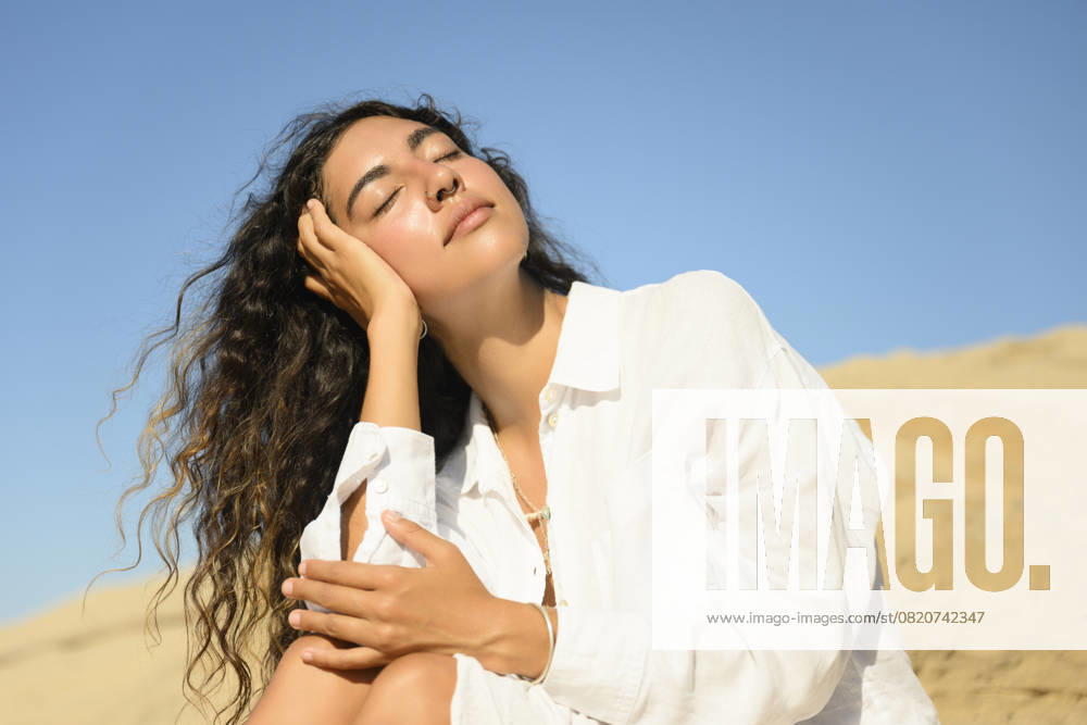 Woman in white dress enjoying sunlight on a sandy dune model released, Symbolfoto property released, FLMZF00525
