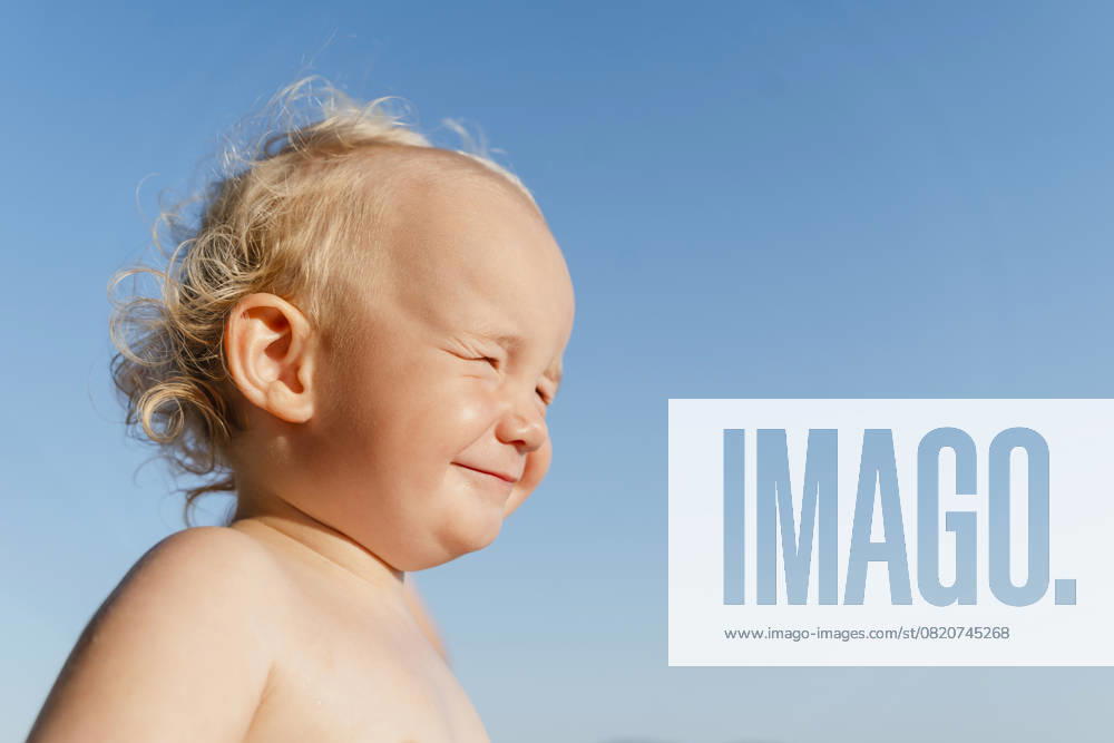 Cheerful child with curly hair smiling in the sun during a summer vacation model released, Symbolfoto, NDEF02282