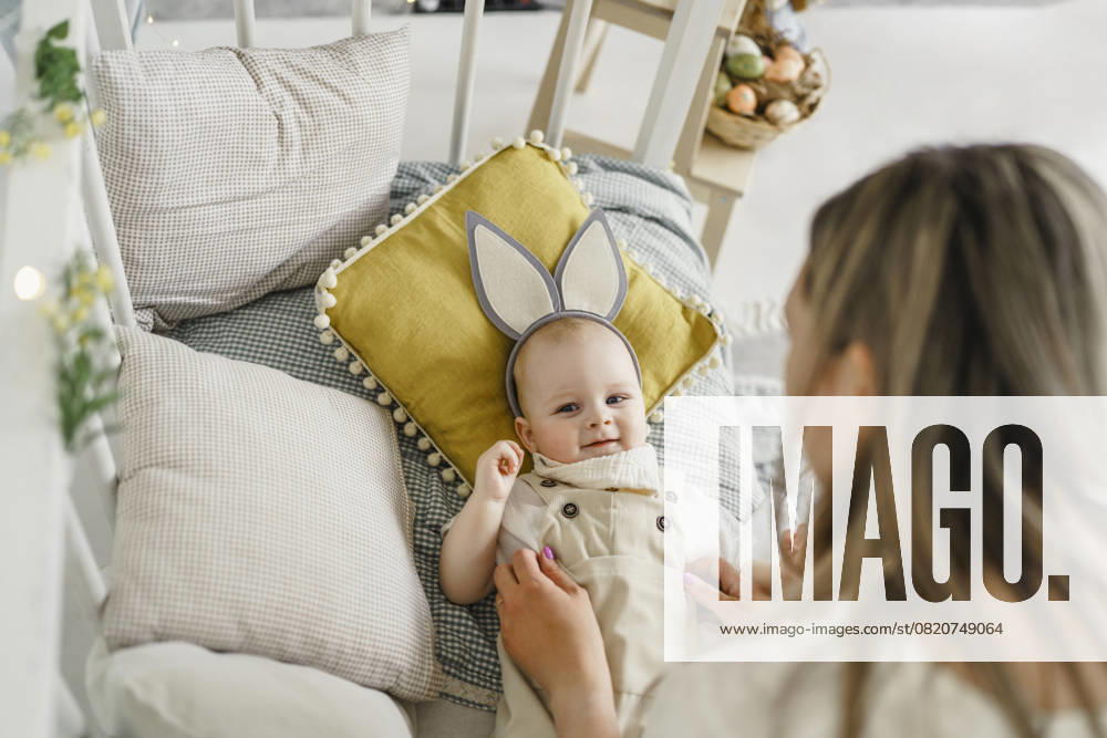 Mother playing with baby wearing bunny ears at home during spring with Easter decor model released, Symbolfoto property released, VBUF00681