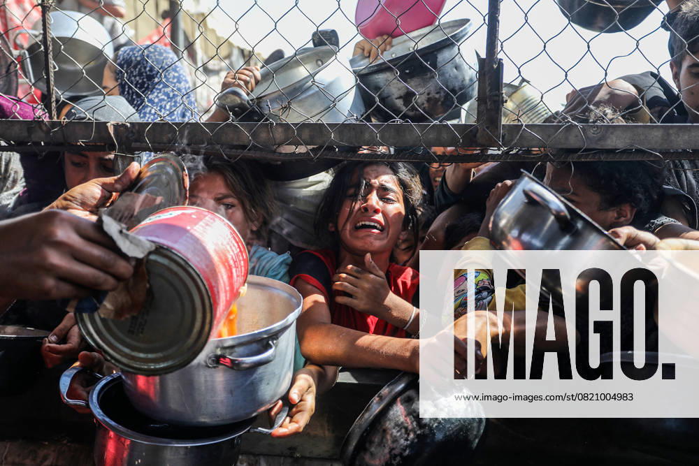 Palestinian girls crowd to receive food portions from a charity kitchen in a refugee camp in Khan Younis, southern Gaza Strip, on Friday, May 30, 2025. GAZ2025053022 AnasxDeeb