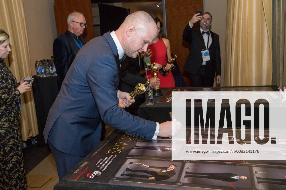 David Malinowski signs a poster backstage with the Oscar for achievement in makeup for work on Darkest Hour during the live ABC Telecast of The 90th Oscars® at the Dolby® Theatre in Hollywood, CA on Sunday