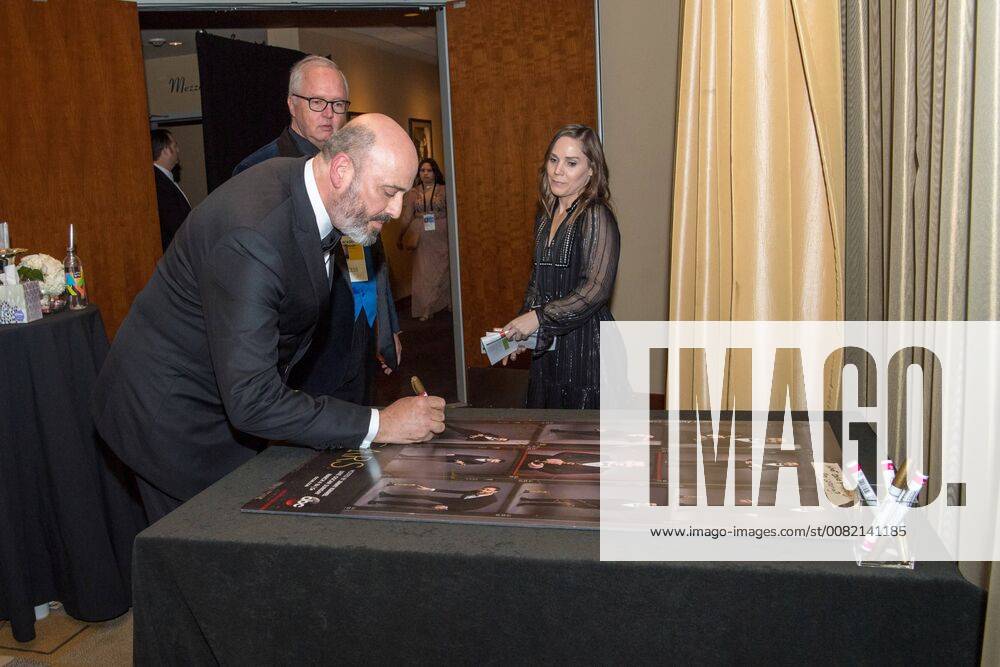 Mark Bridges signs a poster backstage with the Oscar for achievement in costume design for work on Phantom Thread during the live ABC Telecast of The 90th Oscars® at the Dolby® Theatre in Hollywood, CA on Sunday