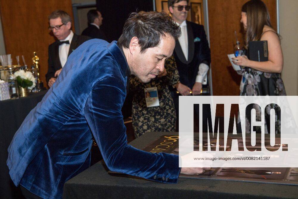 The Oscar winner for achievement in production design for work on The Shape of Water, Paul Denham Austerberry, signs a poster backstage during the live ABC Telecast of The 90th Oscars® at the Dolby® Theatre in Hollywood, CA on Sunday