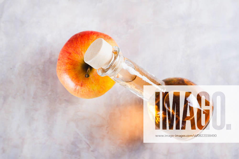 Nahaufnahme von Apfelessig in einer Flasche auf einem frischen Apfel auf dem Tisch Ansicht von oben Nahaufnahme von Apfelessig in einer Flasche auf einem frischen Apfel auf dem Tisch Ansicht von oben (License=RF)