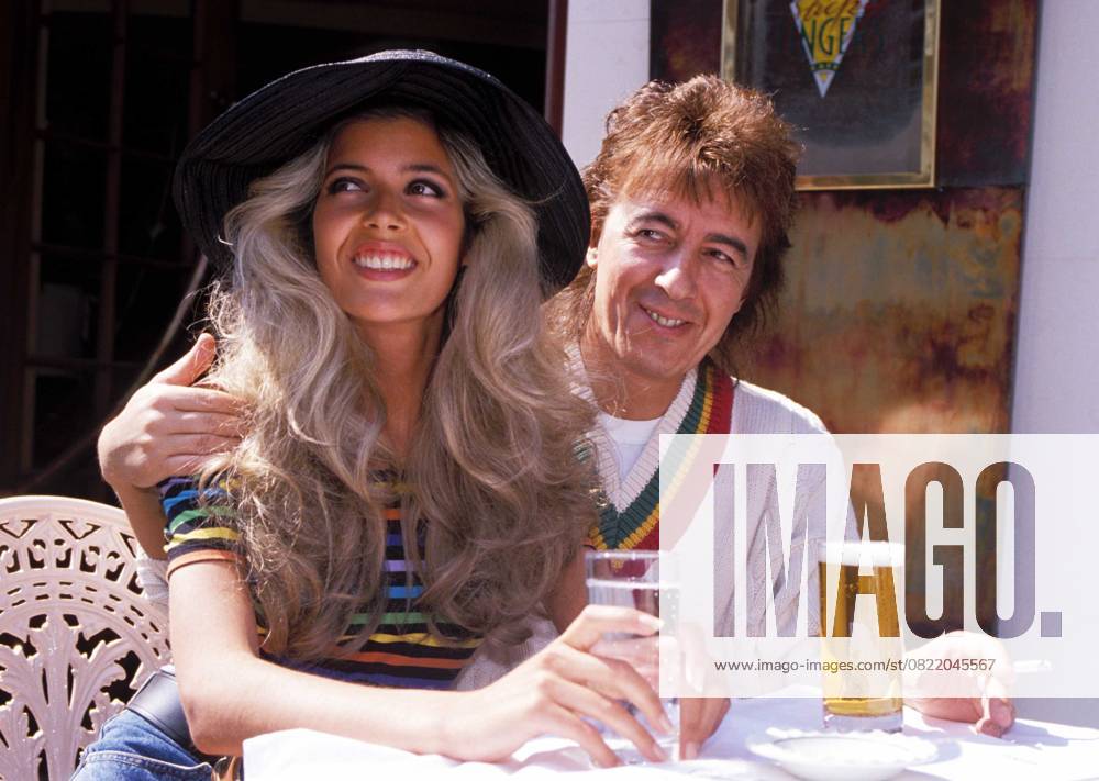 BILL WYMAN ( THE ROLLING STONES ) & MANDY SMITH Ref: 026 eighties fashion, cricket jumper, sweater, hat, smiling, smoking, cigarette London Great Britain