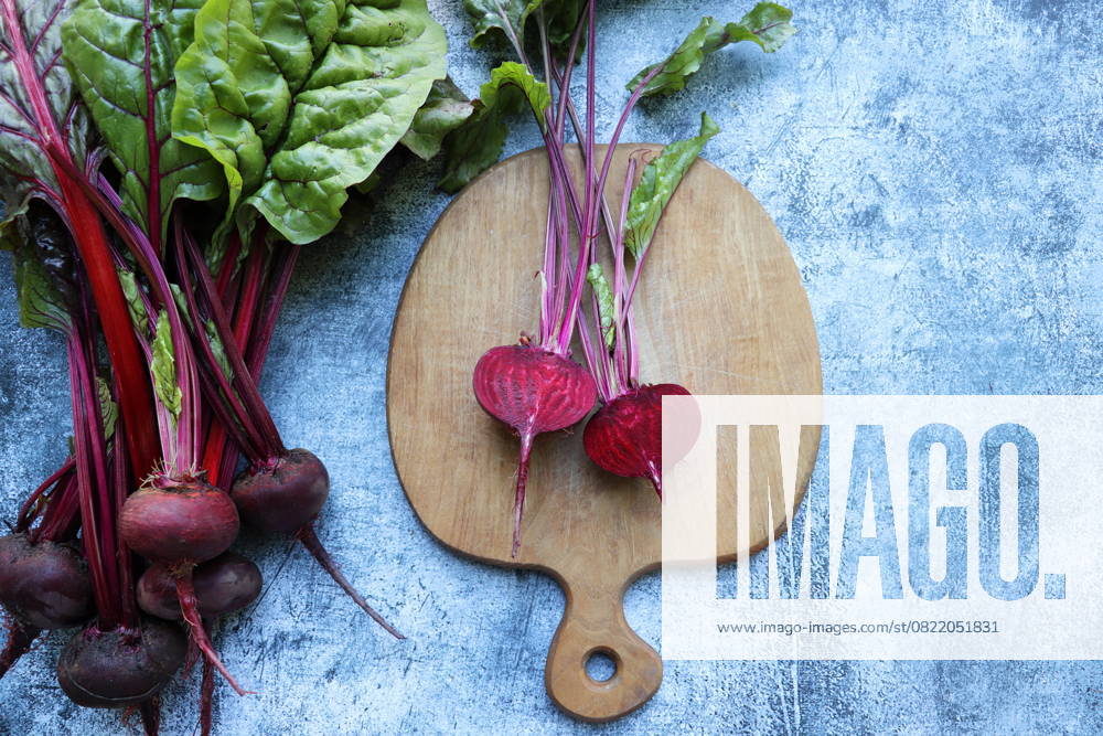 Frische Rote Bete mit Blättern auf blauem Hintergrund. Gesundes Essen. Ansicht von oben. Freier Platz für Ihren Text Fresh beetroot with leaves on a blue background. Healthy food. Top view. Free space for your text. (License=RF)