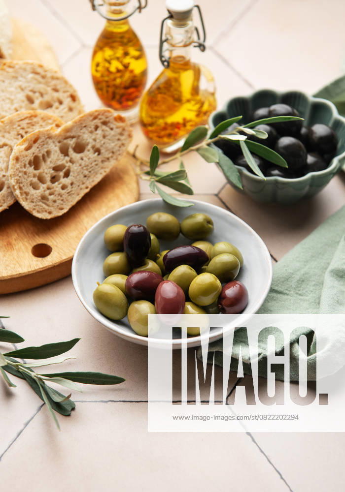 Green and black olives are served with olive oil and bread as part of a healthy mediterranean diet Model Released OlenaRudo_ID28871_858037_011