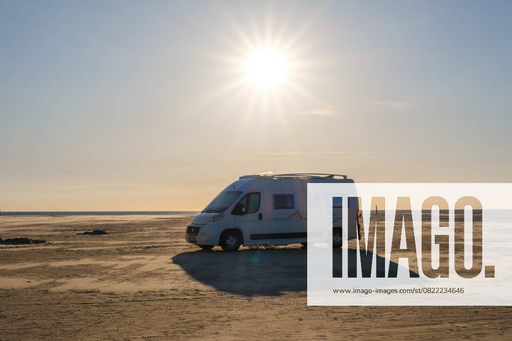Ausgedehnte Strandlandschaft in Dänemark mit einem Wohnmobil unter strahlender Sonne Ausgedehnte Strandlandschaft in Dänemark mit einem Wohnmobil unter strahlender Sonne (License=RF)