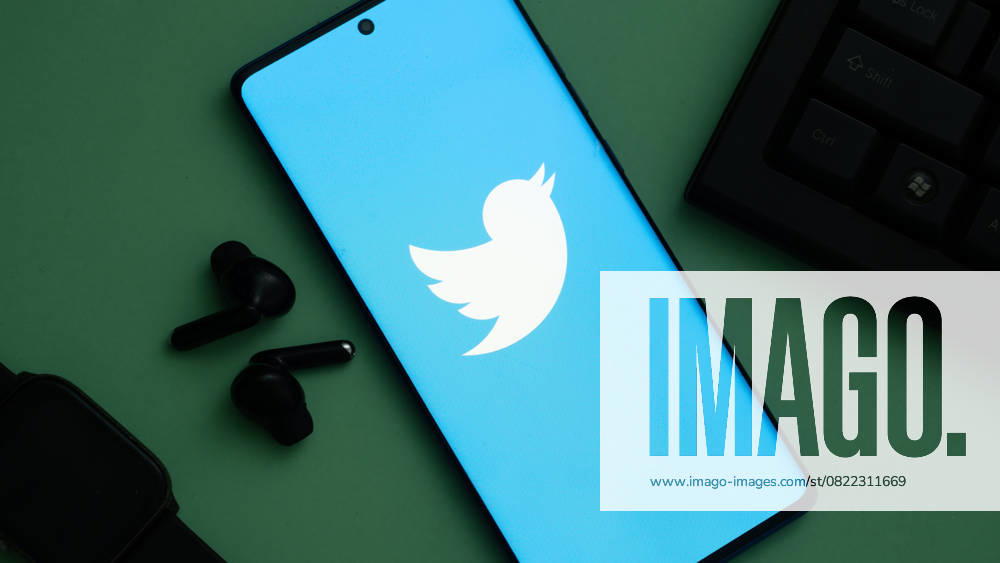 Dhaka, Bangladesch, 24. Mai 2025: Twitter-Logo auf einem Smartphone mit blauem Bildschirm, neben schwarzen Ohrhörern und Tastatur. Dhaka, Bangladesh 24 May 2025:Twitter logo on smartphone with blue screen, seen alongside black earbuds and keyboard. (License=RM)