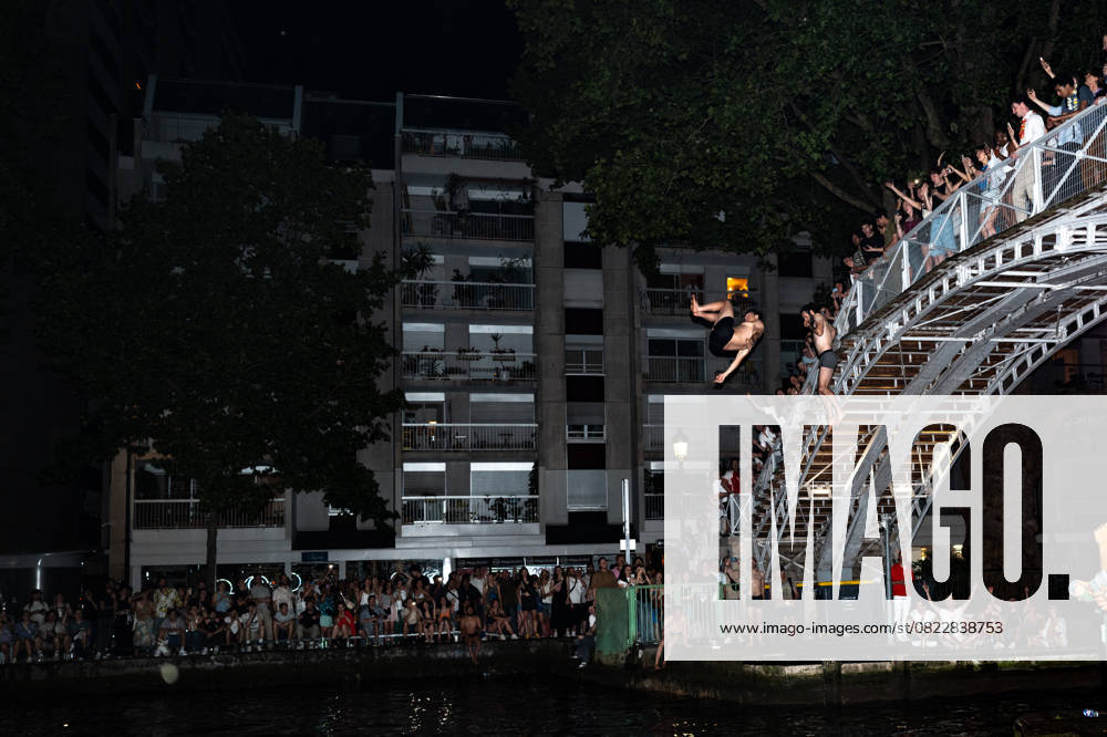 A Huge Crowd In The Streets Of Paris For la Fete De La Musique . Two people jump off the bridge at Canal Saint Martin during France s annual street music festival, the Fete de la Musique, in Paris, France, on June 21, 2025. Paris France