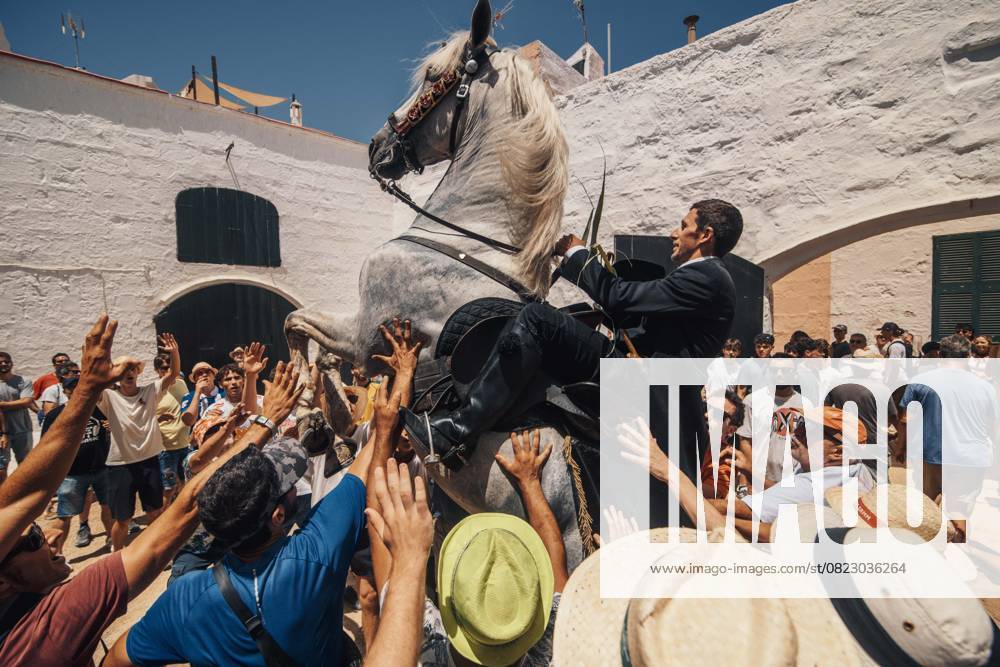 A caixer (horse rider) rears up on his horse surrounded by a cheering crowd during the Caragol de Santa Clara (horse parade) at the traditional Sant Joan (Saint John) festival. Ciutadella De Menorca Spain - ZUMAo105 20250624_fap_o105_044