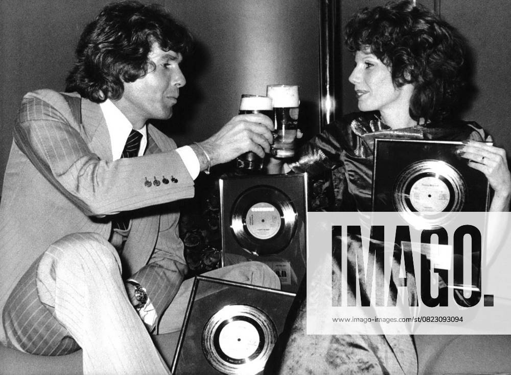 Bands Komponisten Instrumente Musiker Oper Orchester Schallplatten Sänger Songwriter Symphonien 12. Dezember 1973 Drei Goldene Schallplatten für Penny McLean: Prost Sänger Chris Roberts stößt mit Penny McLean an, um ihren dreifachen Goldenen Schallplatten-Erfolg zu feiern. Penny McLean, geboren in Österreich und aufgewachsen in Bayern, erhielt die Goldenen Schallplatten für ihren Hit Lady Bump, von dem sich in Westdeutschland 700.000 Singles, in den Benelux-Ländern 100.000 und in Kanada über 75.000 verkauften. Die erfolgreiche Vertreterin des Sound of Munich ist auch Mitglied der Gruppe Silver Convention, die mit Fly Robin Fly einen Hit landete. London England United Ki