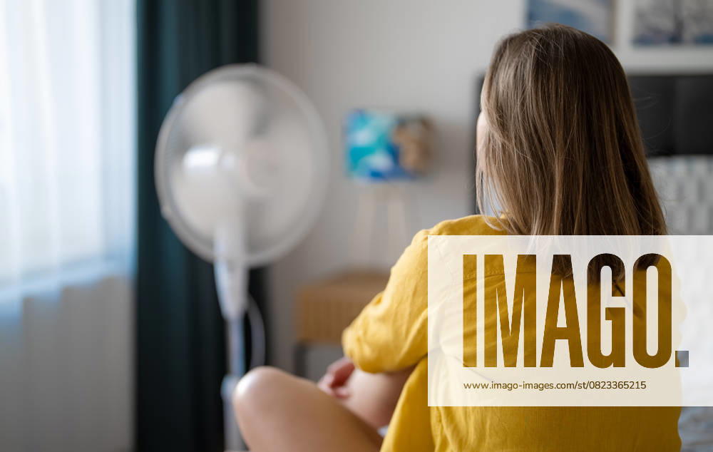 IMAGO Creative, Gesellschaft, Leisure Sickness Frau leidet unter extremer Sommerhitze in einem Haus. Woman suffering from extreme summer heat indoors. (License=RF) ,model released, Symbolfoto