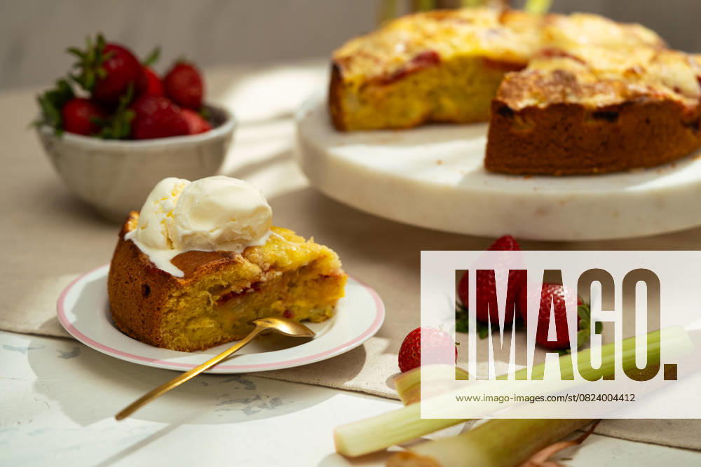 Strawberry rhubarb cake with ice cream on a plate A delicious homemade strawberry rhubarb cake topped with a scoop of creamy vanilla ice cream, served on a decorative plate. Fresh strawberries and rhubarb complement the sweet flavors Model Released Ellsy_ID29794_1007205_003