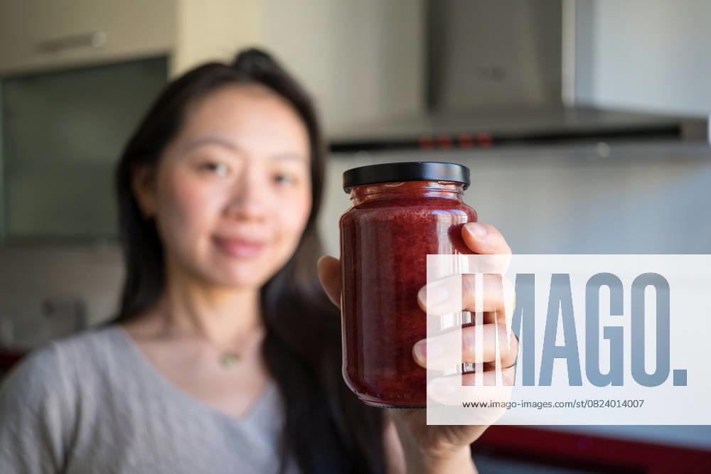 IMAGO Creative, Jahreszeit Sommer, Food, Marmelade kochen Homemade strawberry jam in cozy kitchen setting Young Asian woman crafting homemade strawberry jam in a cozy kitchen. Emphasizing healthy eating, sustainable living, and zero-waste practices for a conscious lifestyle Model Released JuanAlbertoRuiz_ID29313_965720_019