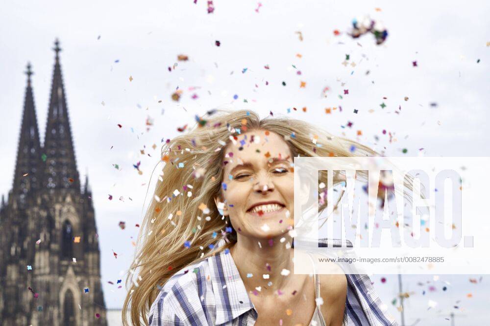 Germany, Cologne, portrait of happy blond woman in between shower of confetti model released Symbolfoto FMKF04742