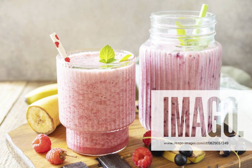 Set von frischen verschiedenen leckeren Milchshakes oder Smoothies mit frischen Beeren auf einem rustikalen Hintergrund. Himbeeren und schwarze Johannisbeeren Set of fresh various delicious milkshakes or smoothies with fresh berries on a rustic background. Raspberries and black currant