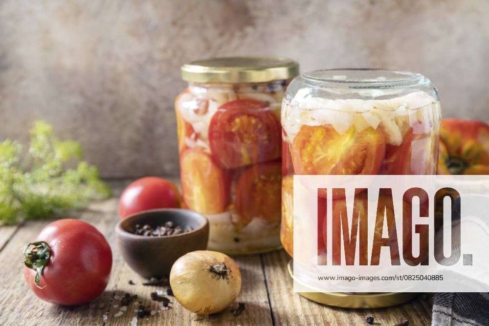 Gesunde hausgemachte fermentierte Lebensmittel. Gesalzene eingelegte Tomaten und Zwiebeln in Glaskonserven. Hauswirtschaft, Konservierung der Herbsternte. Platz zum Kopieren Healthy homemade fermented food. Salted pickled tomatoes and onions preserved canned in glass jar. Home economics, autumn harvest preservation. Copy space