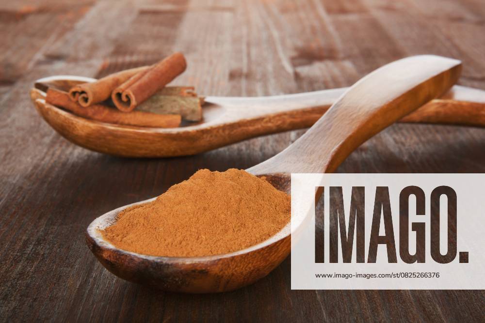 Zimt Konzept. Sticks und Pulver auf Holzlöffel auf hölzernen Hintergrund. Aromatische kulinarische Gewürze Cinnamon concept. Sticks and powder on wooden spoons on wooden background. Aromatic culinary spices
