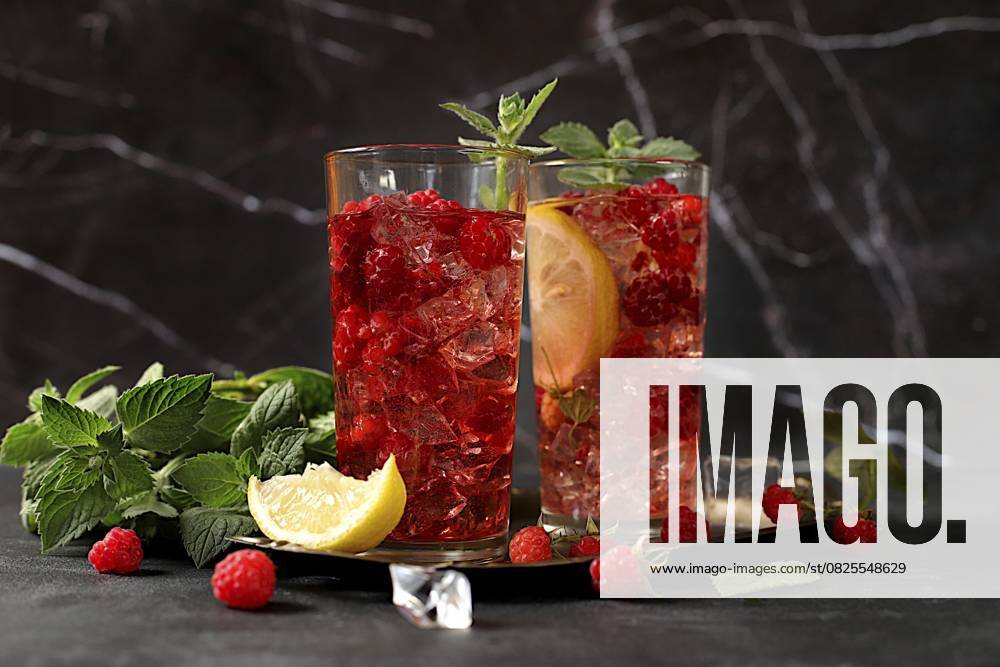 Erfrischender Sommercocktail mit hausgemachter Limonade, Mojito mit Himbeeren, Johannisbeeren, Minze und Zitrone, Entgiftungswasser mit Fruchtgeschmack, Konzept zur Gewichtsabnahme, gesunde und natürliche Ernährung, gezielte Konzentration Refreshing summer homemade lemonade cocktail, mojito with raspberries, currants, mint and lemon, fruit flavored detox water, weight loss concept, healthy and natural food, selective focus