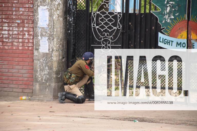 Srinagar, Jammu & Kashmir, India - A policeman pointing tearshell towards the students inside college through gate during clashes with Students in Srinagar, Indian administered Kashmir. Srinagar India - ZUMAs197 20180405_zaa_s197_028