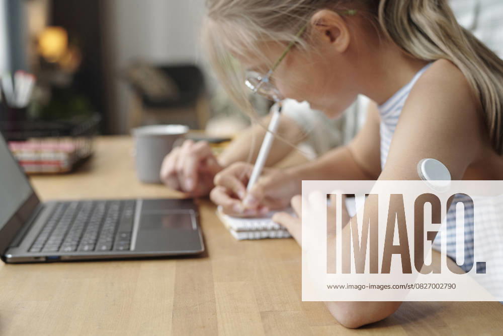 Diabetic student with insulin patch doing homework with parent at home model released, Symbolfoto property released, DSHF02368