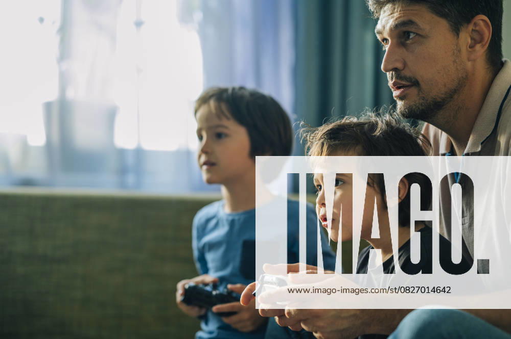 IMAGO Creative, Lifestyle, Gaming Father and children playing video game together at home model released, Symbolfoto property released, ANAF04842
