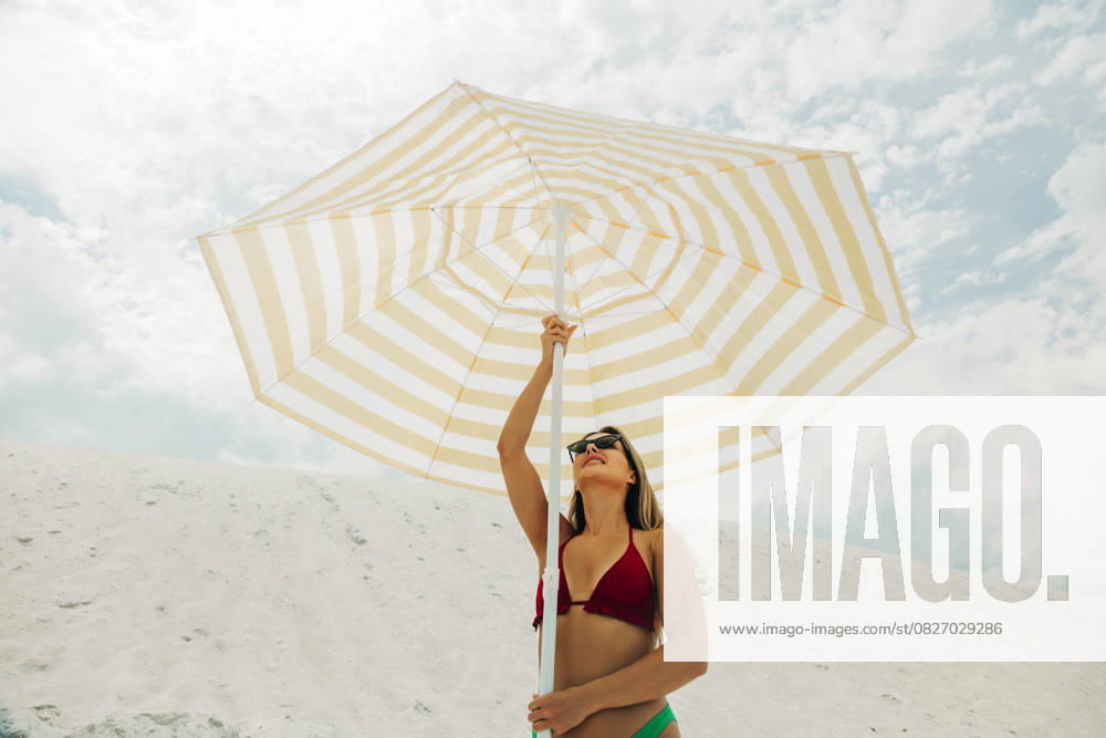 Creative Highlight Symbolbilder Woman in bikini with sunglasses holding umbrella at sandy summer beach model released, Symbolfoto, VSNF03669