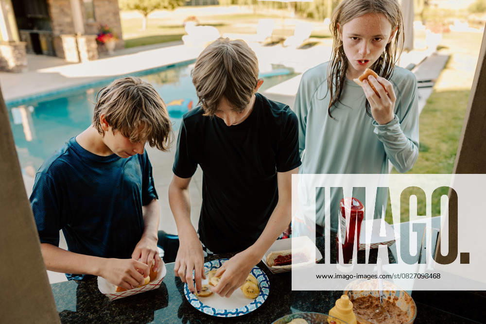 Teenagers preparing hot dogs and fruit by the pool Eagle, Idaho, United States R_PHZD250722-1776536-01 ,model released, Symbolfoto