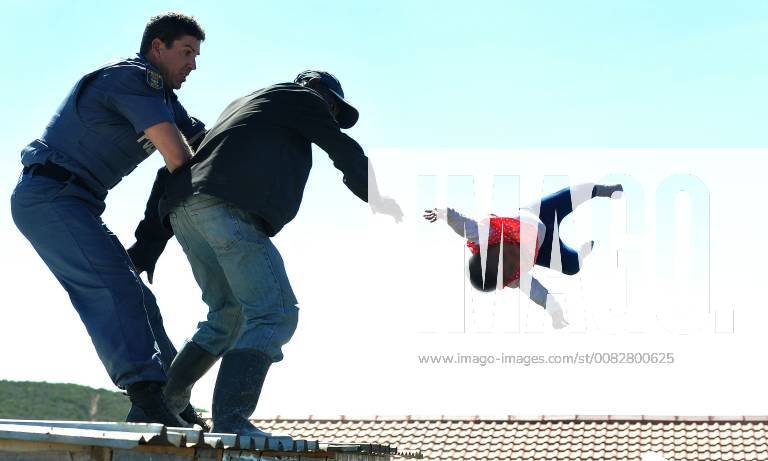 Father nabbed after flinging daughter off shack roof PORT ELIZABETH, SOUTH AFRICA ? APRIL 12: A man scuffles with a police officer as he flings his six-month-old baby off the roof of a shack at the Joe Slovo informal settlement on April 12, 2018 in Port Elizabeth, South Africa. The man who flung his child while resisting the demolition of an illegal structure was arrested and charged with attempted murder. A group of policemen who had surrounded the shack managed to catch the baby. ( Gallo0000263983