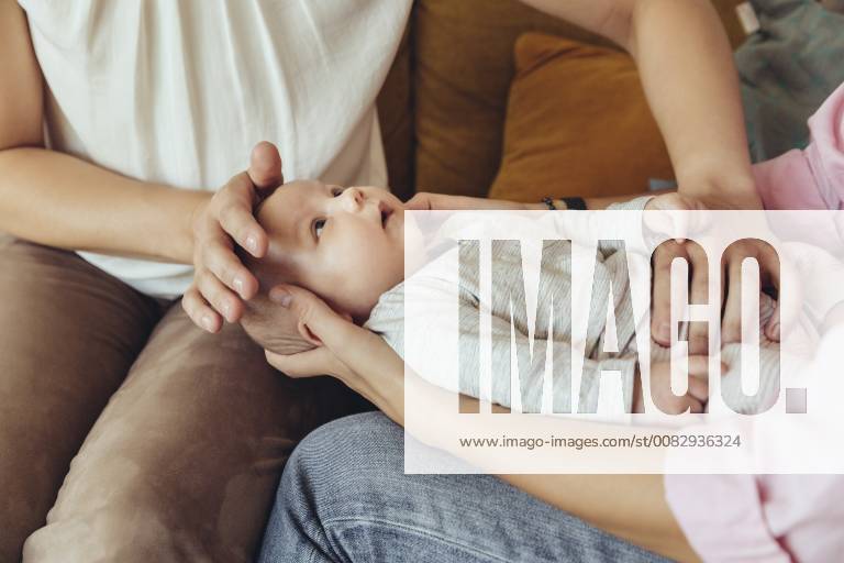 Midwife and mother giving newborn baby a belly massage to help with digestion model released Symbolfoto property released MFF04396