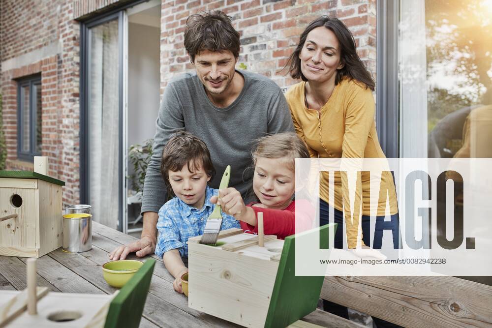 Family working on birdhouse in front of their home model released Symbolfoto property released RORF01211