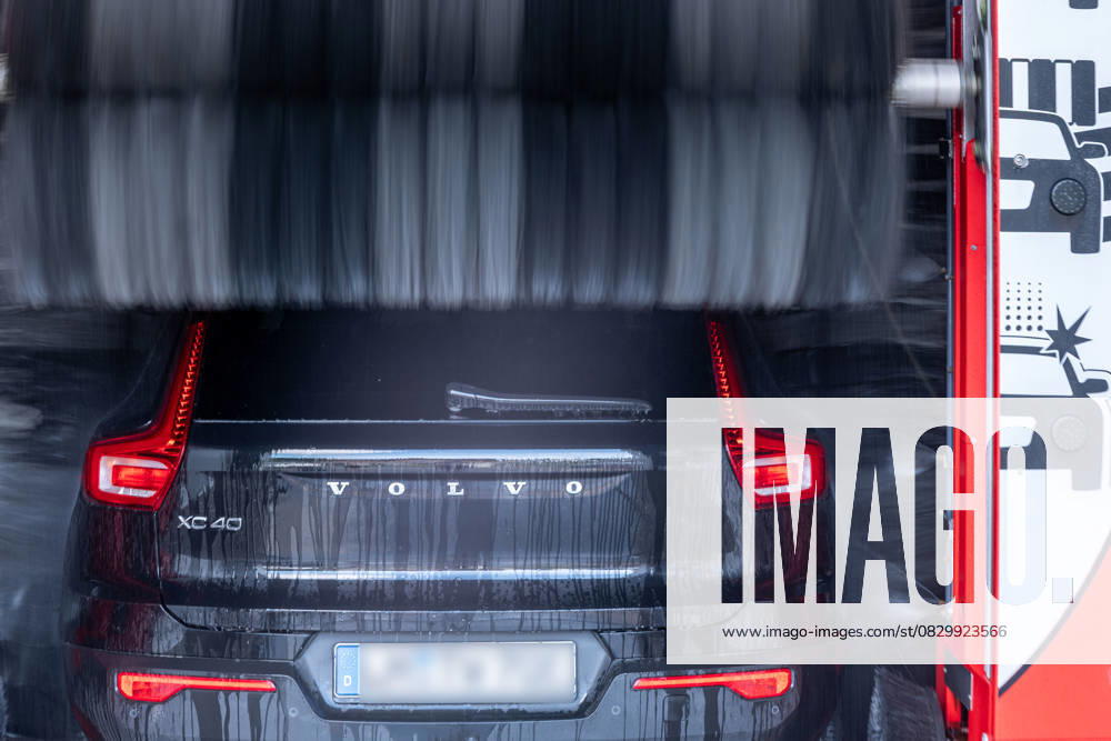 Volvo XC40 in automatic car wash 08 08 25, Selters Symbol photo, illustration image, symbol image, illustration photo, everyday scene A black Volvo XC40 drives into a red WashTec car wash water sprays from above onto the vehicle while an illuminated stop signal is visible on the left side The photo