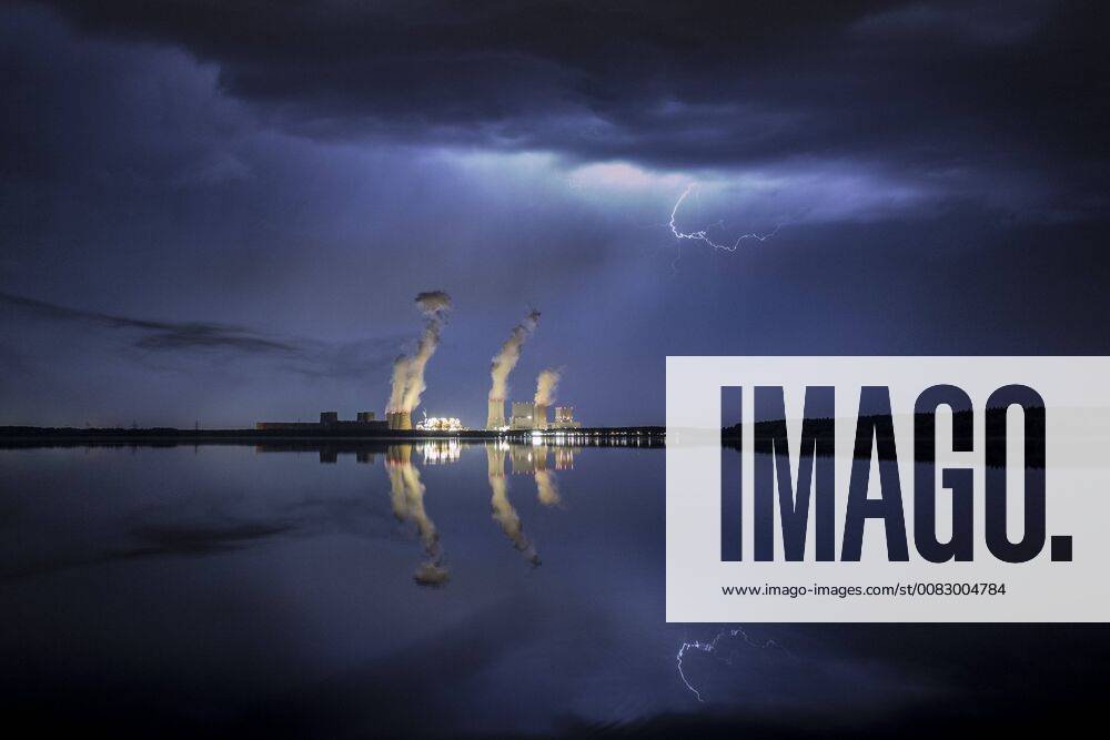 A thunderstorm with lightning is visible behind the Baerwalder See and the coal power plant of Boxberg in Oberlausitz Klitten 28 04 2018 Klitten Germany