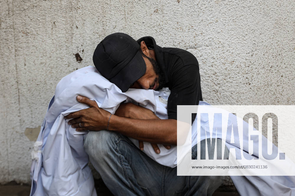 Israeli attacks on Gaza continue GAZA CITY, GAZA - AUGUST 12: A man hugs the lifeless body of a person who were killed in an Israeli attack, at Al Shifa Hospital in Gaza City, Gaza on August 12, 2025. Abdalhkem Abu Riash Anadolu Gaza City Gaza. Editorial use only. Please get in touch for any other usage.