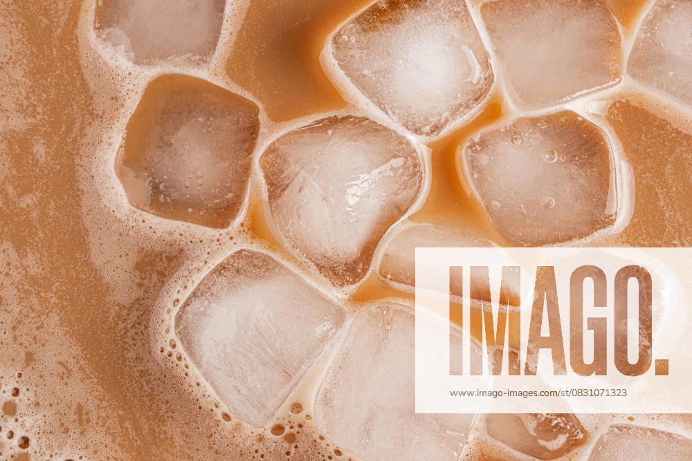 IMAGO Creative, Food, Trend, Iced Coffee Close-up of iced cold brew coffee with ice cubes A detailed top-down view of iced cold brew coffee, showcasing ice cubes floating in the brew. The light brown coffee contrasts against the clarity of the ice, suggesting refreshment. Model Released MarinaMos_ID30595_1034926_006