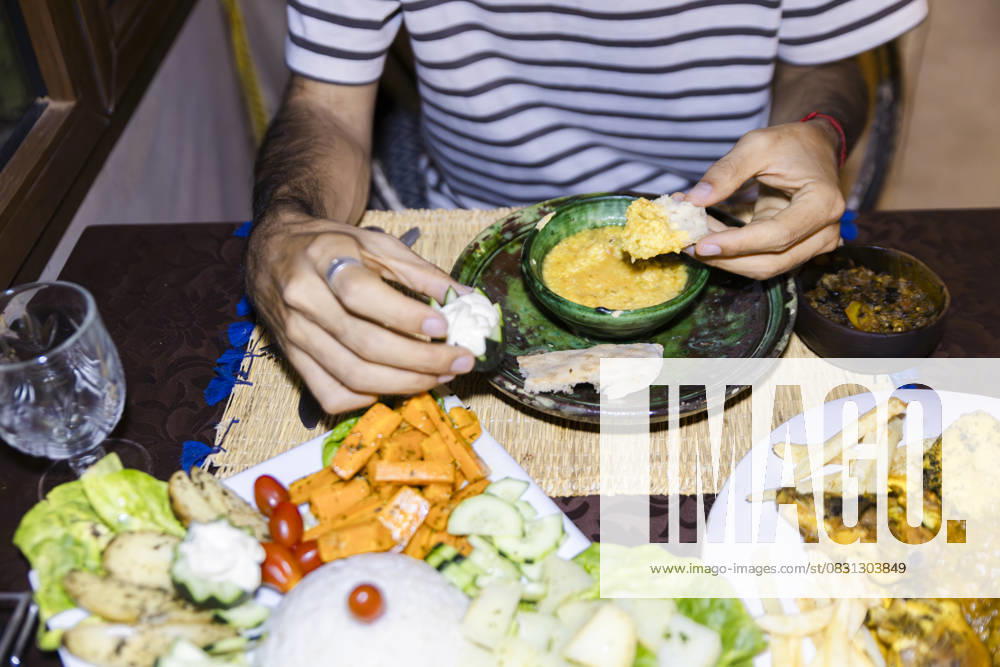 Person enjoying traditional Moroccan meal in cozy Sahara desert camp model released, Symbolfoto property released, PCLF02255