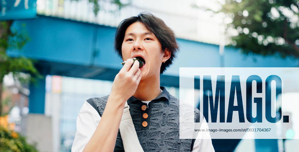 IMAGO Creative, Food, Japan, Onigiri Asian man, eating and street food in city for travel, hungry and traditional snack on afternoon commute in Japan. Student, walk and onigiri in Tokyo for lunch, wellness and local meal with culture Asian man, eating and street food in city for travel, hungry and traditional snack on afternoon commute in Japan. Student, walk and onigiri in Tokyo for lunch, wellness and local meal with culture., model released, , 63251284.jpg RECORD DATE NOT STATED