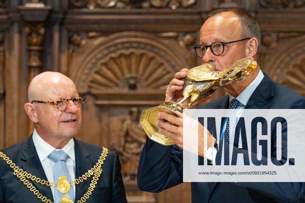 Federal Chancellor Friedrich Merz is presented with the traditional Golden Rooster by Lord Mayor Markus Lewe and drinks from it in the Friedenssaal Chancellors inaugural visit to North Rhine-Westphalia Münster , Münster North Rhine-Westphalia Germany City Hall
