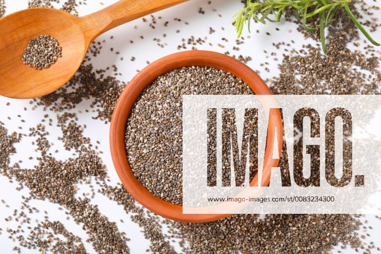 Bowl of healthy chia seeds and wooden spoon on white background CTKPhotoF201805161195601