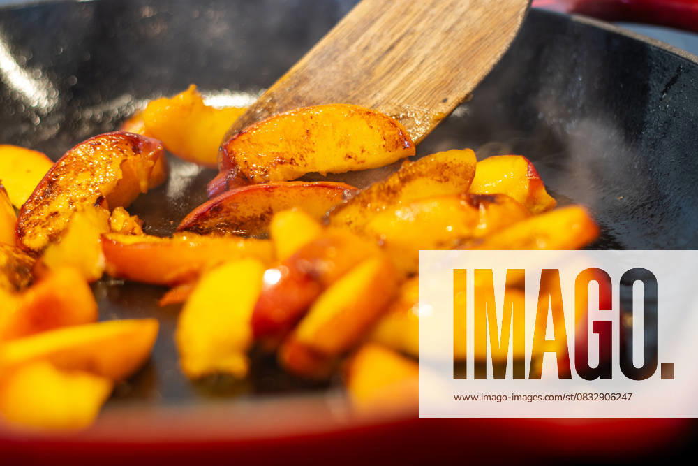 Caramelizing peach slices in a hot skillet with steam rising Kelowna, British Columbia, Canada R_PESF2509050A-1816836-01