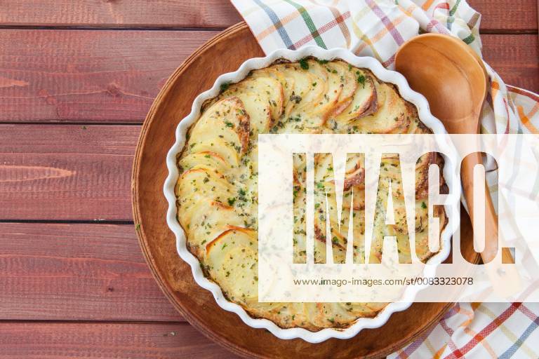 Homemade potato gratin in baking dish on a rustic wooden background Homemade potato gratin 1079704952