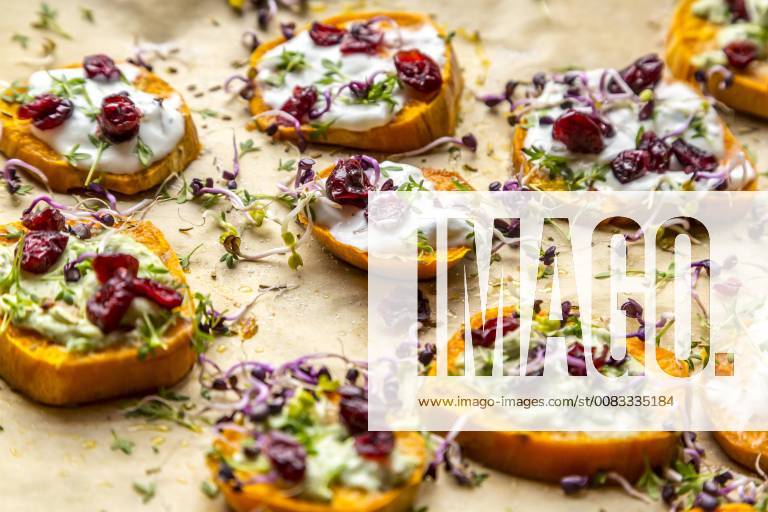 Slices of sweet potato with cream cheese, ramson cream, goat cheese, cress and cranberries SARF03645