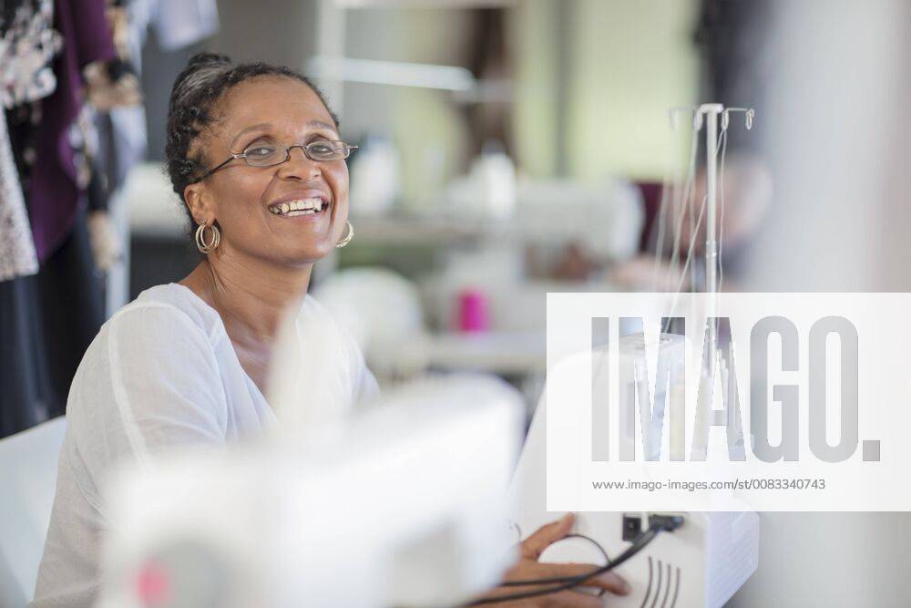 Portrait of happy seamstress with sewing machine model released Symbolfoto property released ZEF15336
