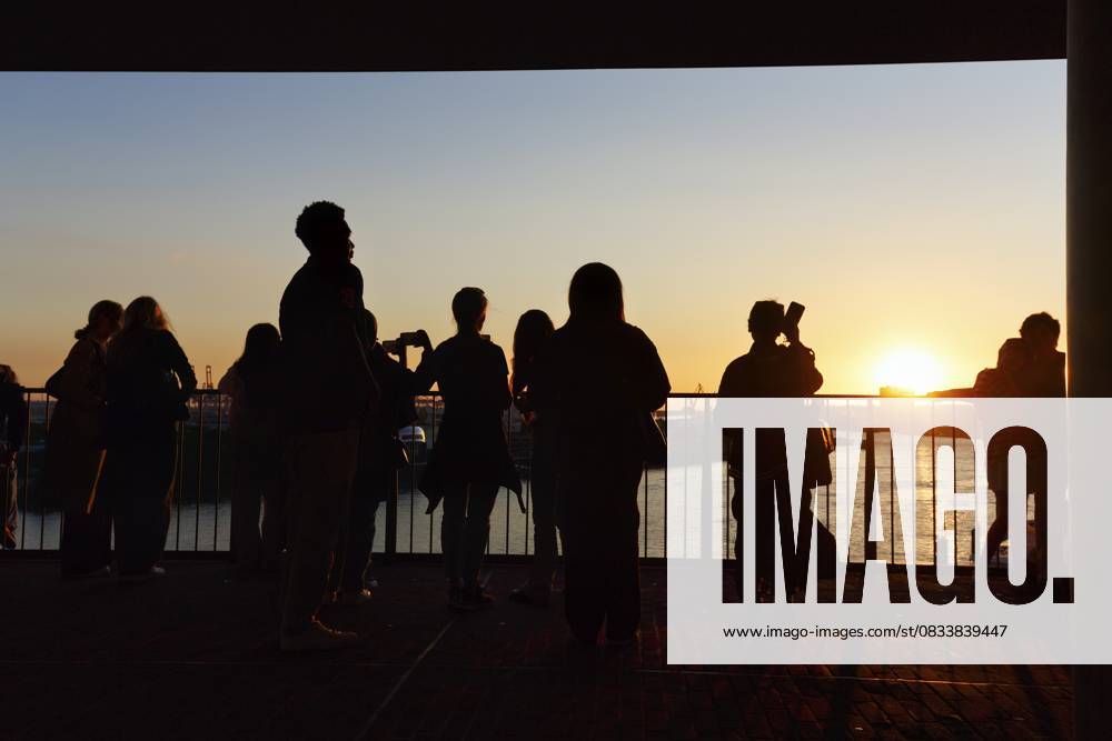 Menschenmenge genießt Ausblick von der Elbphilharmonie über die Elbe bei Sonnenuntergang, Silhouetten, Aussichtsplattform Plaza, Hamburg, Deutschland Crowd enjoying the view from the Elbphilharmonie over the Elbe at sunset, silhouettes, Plaza viewing platform, Hamburg, Germany