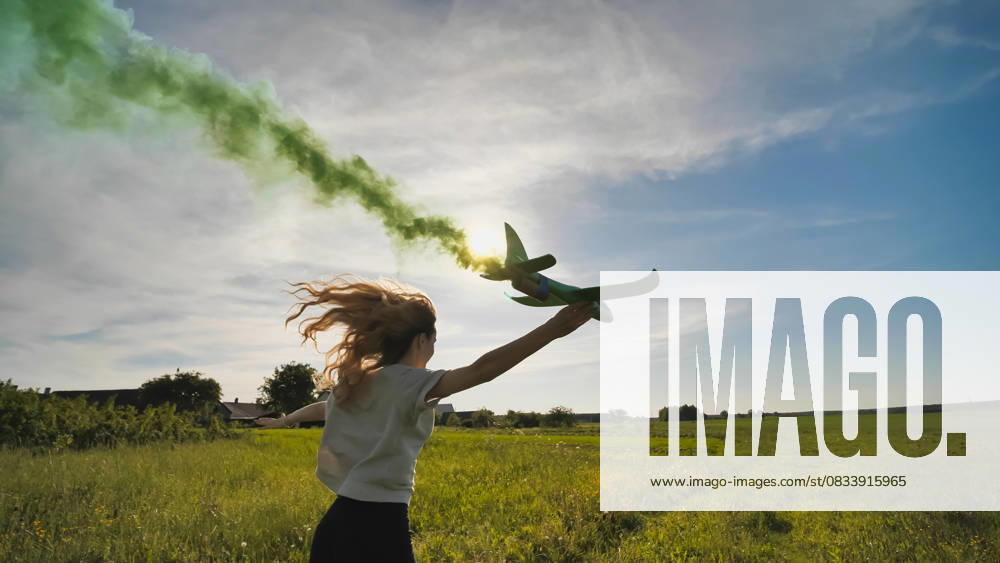 A young girl with a toy airplane smokes colorful smoke on a summer evening. A young girl with a toy airplane smokes colorful smoke on a summer evening, model released, , 95801254.jpg RECORD DATE NOT STATED