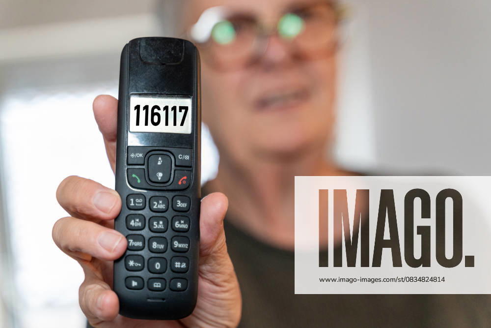 PHOTOMONTAGE, A woman holds a telephone with the number 116117 on the display. Symbolic image for the medical on-call service in Germany. Contact point for patients who need help outside surgery hours